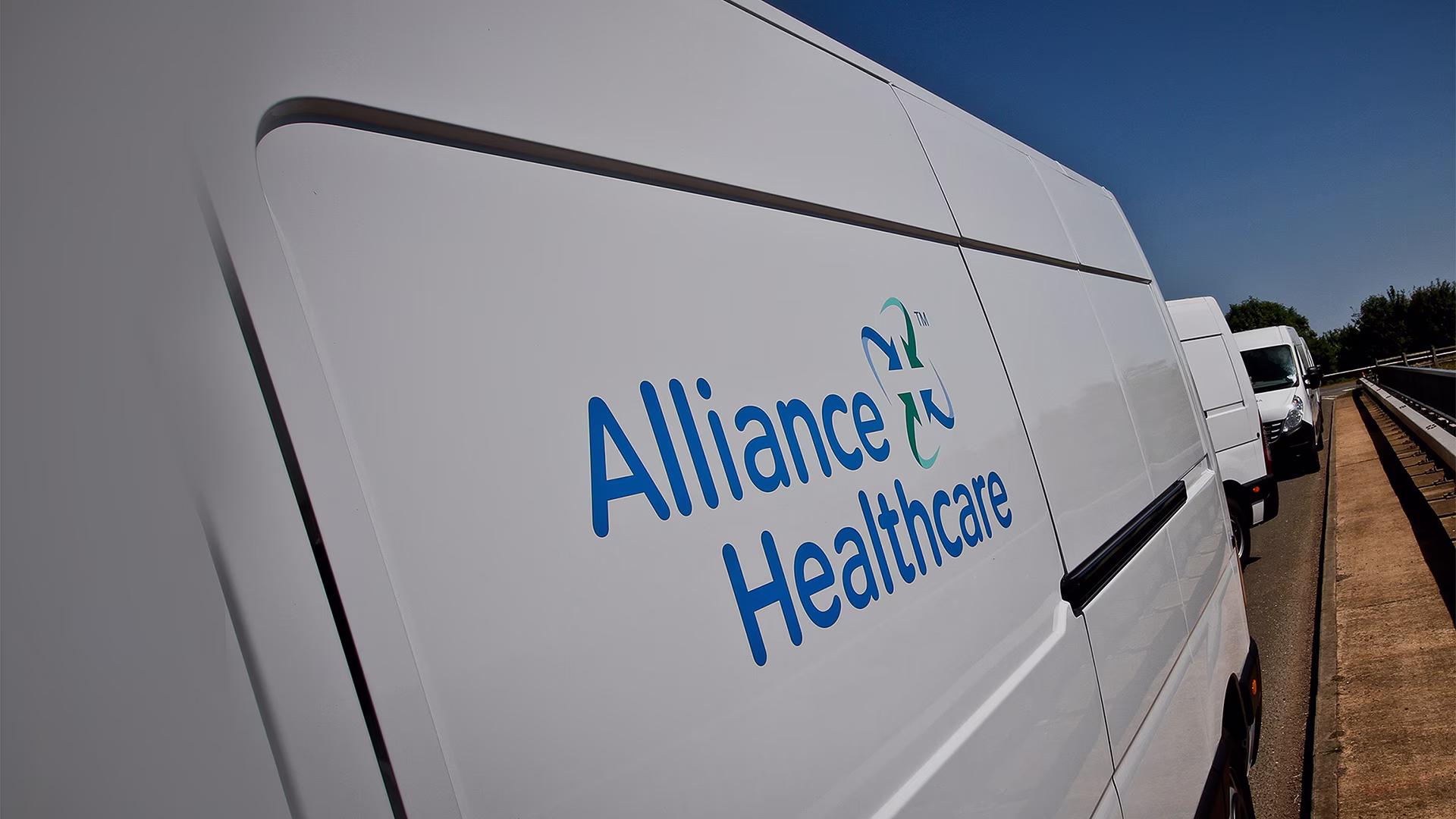 Witte bedrijfswagen met Alliance HealthCare logo op de zijkant