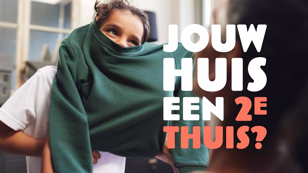 Vrouw met groene deken thuiswerkt op laptop