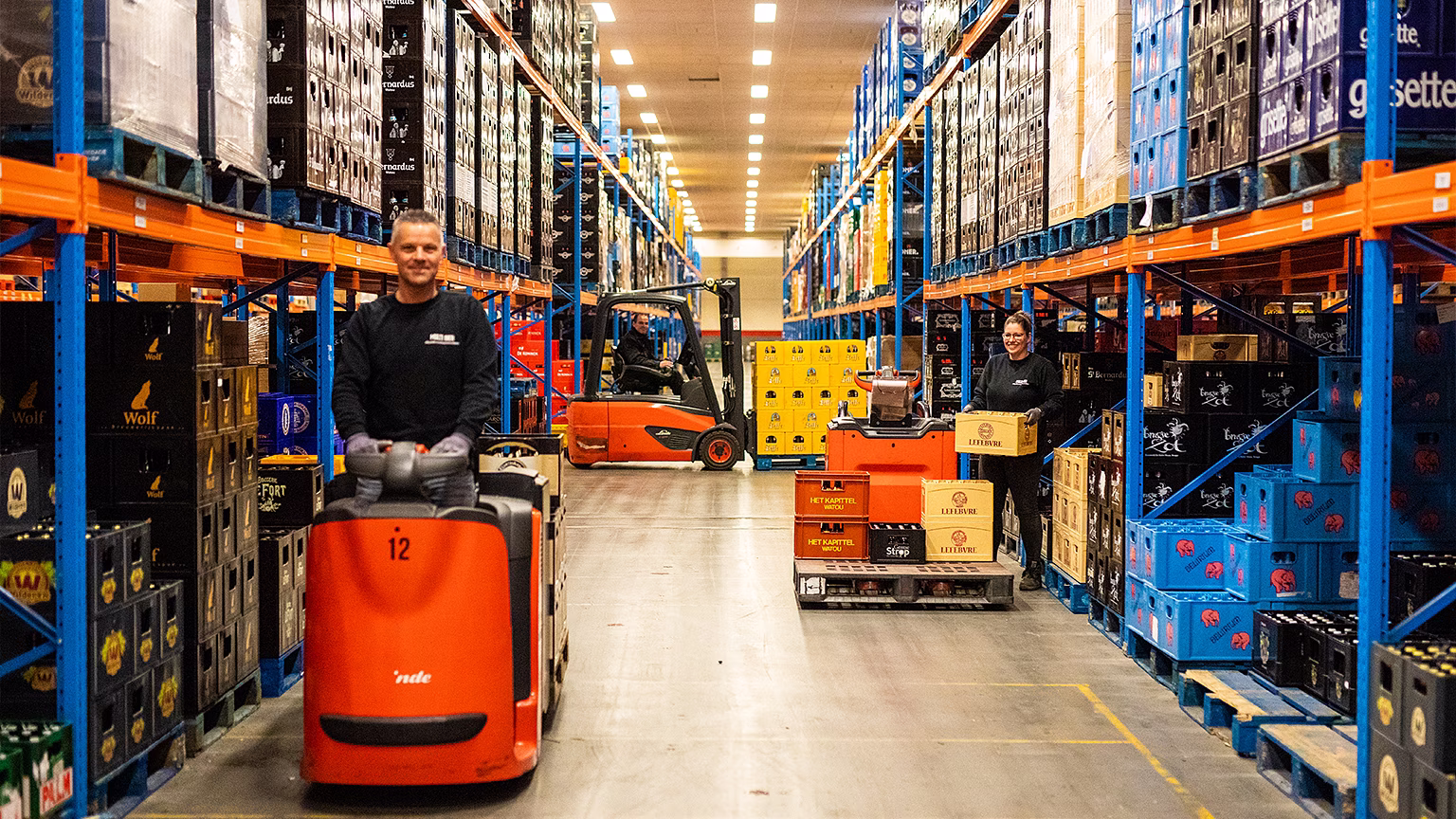 Oranje vorkheftrucks in een modern magazijn met hoge stellingen