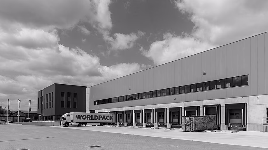 Zwart-wit foto van een leegstaand winkelcentrum met parkeerplaats