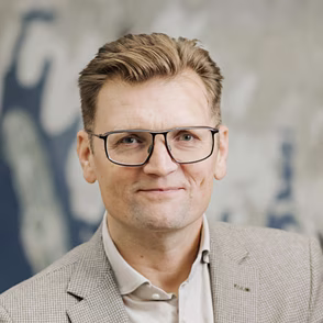 Professionele portretfoto van een blonde man met bril in beige colbert